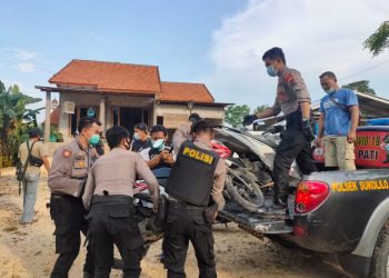 Aparat kepolisian mengangkat sejumlah sepeda motor saat penggrebekan judi sabung ayam di kabupaten Pati.